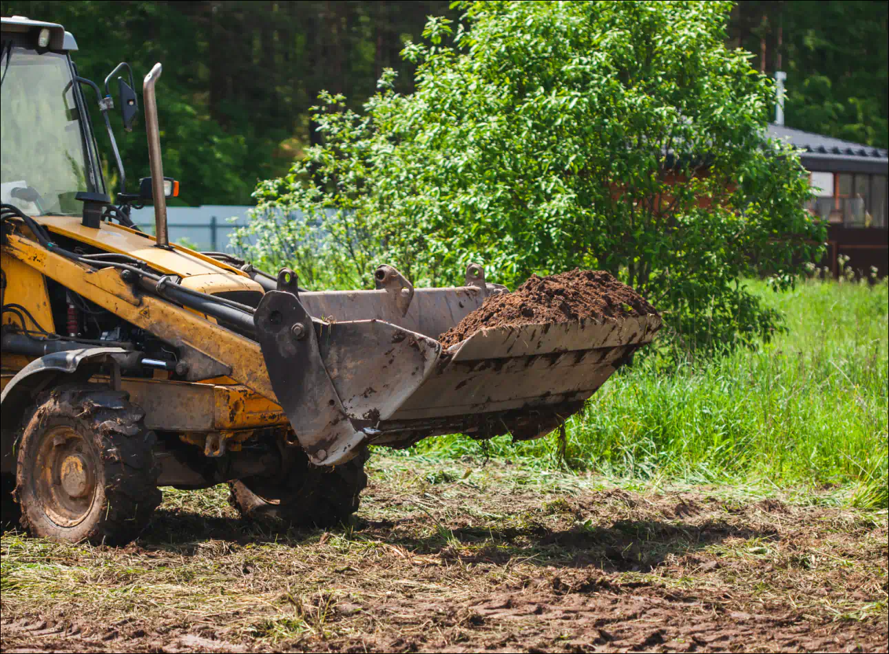 a backhoe loader carrying moving dirt